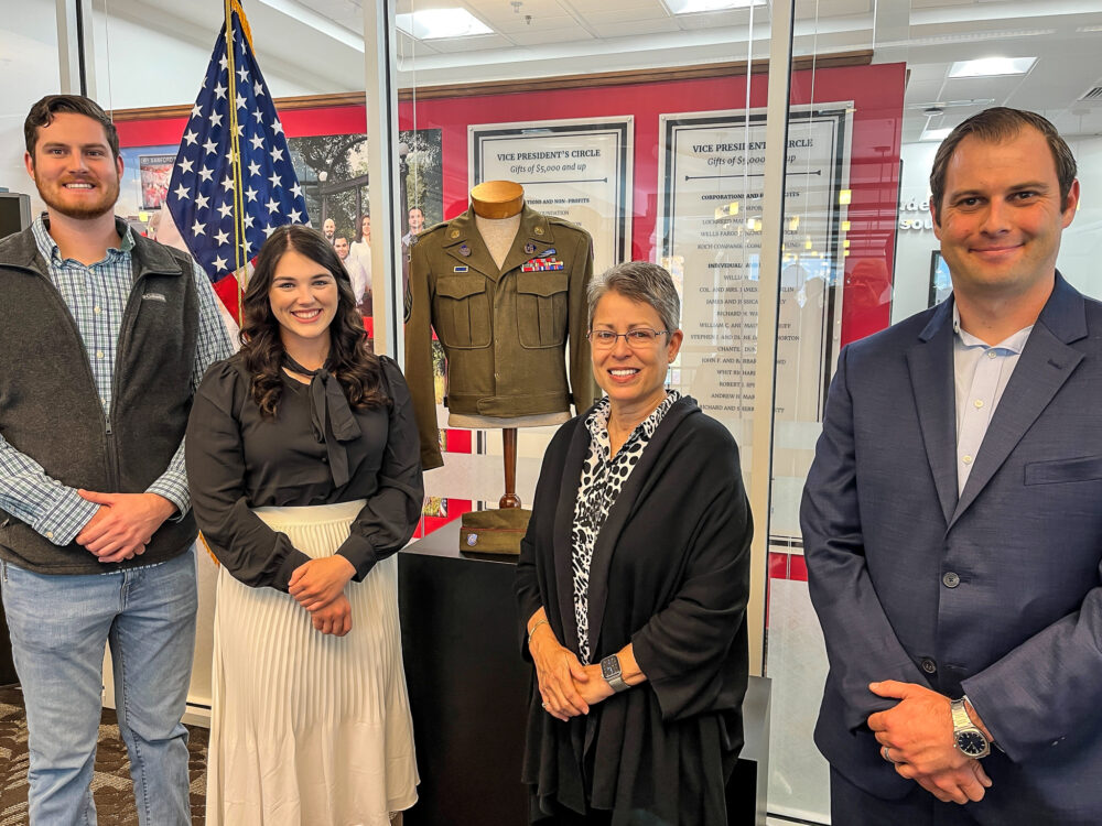Three student veterans flank Mrs. Berkman and Harold Berkman's jacket.